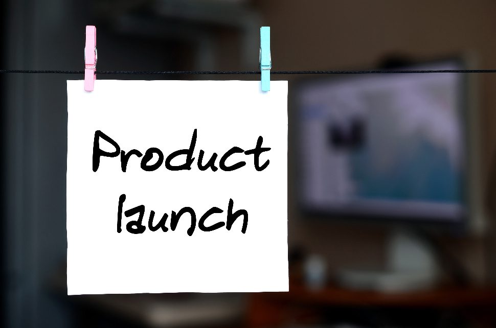 Sticky note saying product launch and held with pins