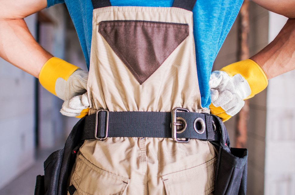 Contractor worker with tool belt and work gloves at a job