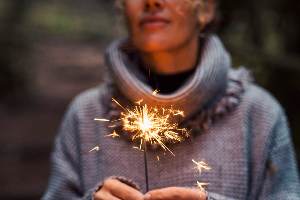 Woman holding a sparkler to celebrate the new year